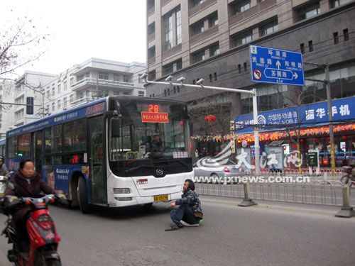 男子蹲坐路中央拦公交致堵车两百米(组图)