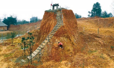 墳的四周被掏空,一座土堆矗立,旁邊修建了樓梯和扶手.