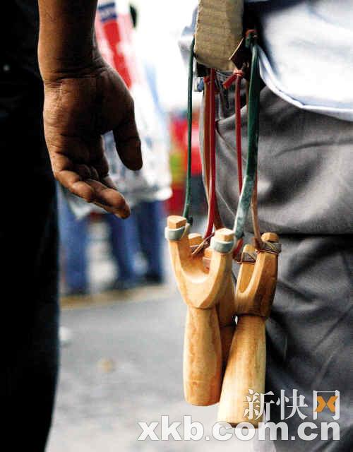 一名反政府示威者腰间挂着弹弓■2日,泰国军警将冲突双方分隔离 