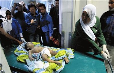 几名医护人员将一名在轰炸中受伤的小女孩送进医院