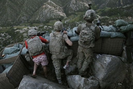 图为美国士兵向掩体外的塔利班武装分子还击