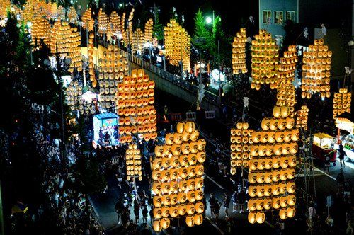 日本举行竿灯节男子用额头等托起竿灯图
