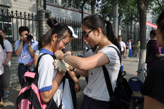 班主任老师给考生戴上幸运符北京考试报记者 安 坤 摄