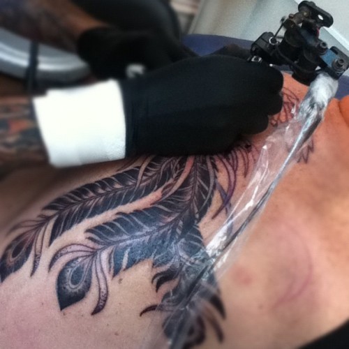 纹身中,一只凤凰看起来像是没穿衣服的亡灵女一个不知名的符号口含