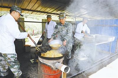 下连当兵的代理师长张久彪(左一)拜战士为师,熟悉掌握新装备.