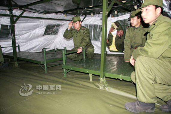 图文:军人在b型宿营帐篷底层摆放折叠床