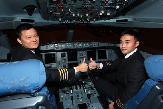 最后一个航班降落,机长许学军(左)和副驾驶彭翔(右)同时竖起大拇指