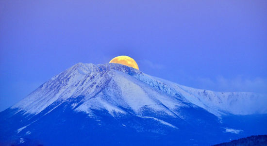 美国摄影师严寒中拍残冬山头满月