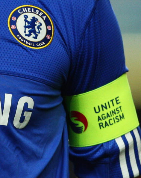 图为队长特里的袖标上印有反对种族歧视的标语.