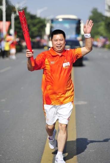 图文-广州亚运会火炬在清远传递 火炬手黄锐奔跑